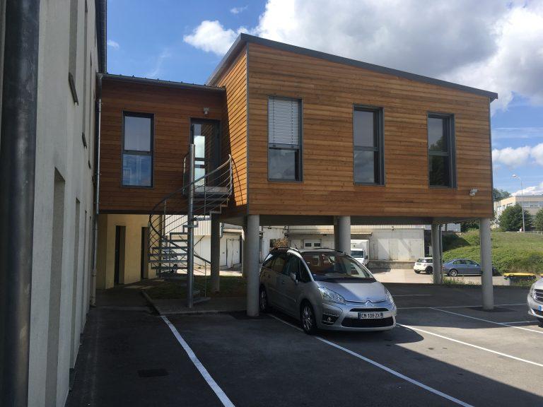 Vue de côté d'une extension de bureau sur pilotis construite par Seguin maitrise d'œuvre.